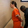 Female prisoner handcuffed in jail cell