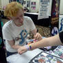 Signing a fan's arm at Cutie Mark Con