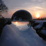 Crystaline sphere on snow pile at sunset