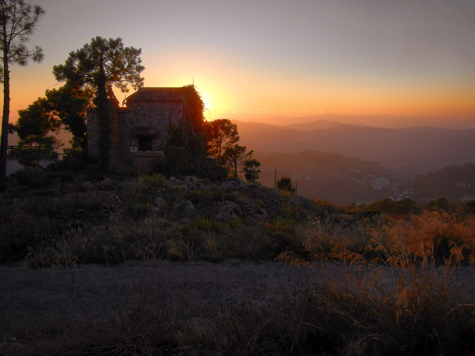 Sunset behind a stone house