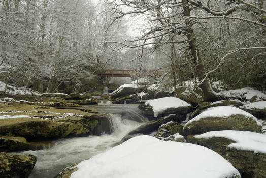 Snow stream rock foot-bridge stock