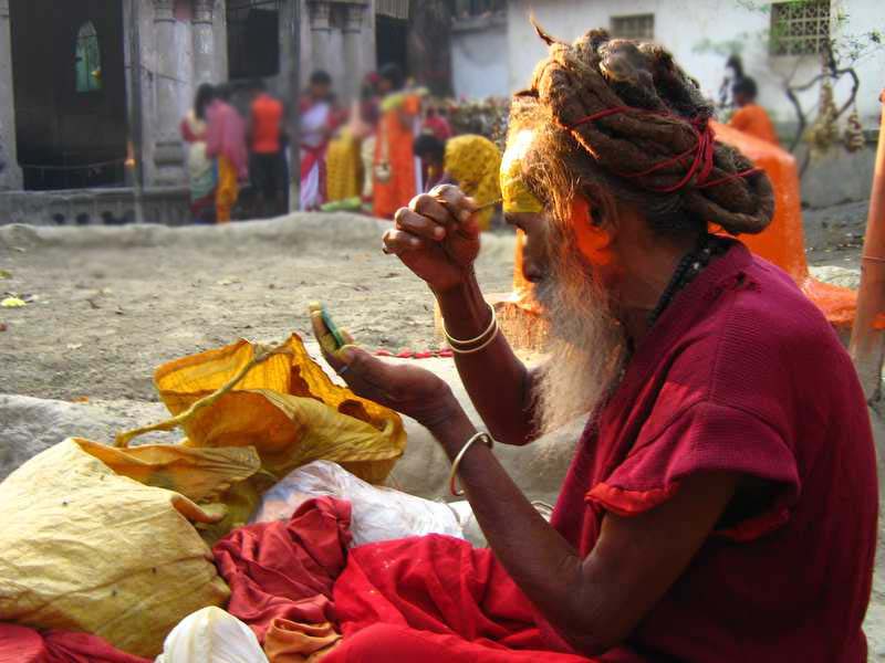 A sadhu is applying Tilak