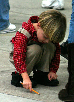 Little Boy Drawing on Ground