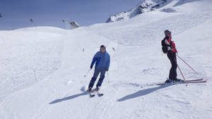 Skiers on downhill, sunny day