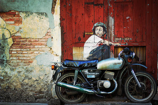 the boy, the door, wall, and a motocycle