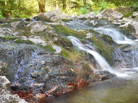 Water falling among the mossy and redish rocks