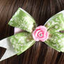 Green lace bow with pink rhinestone center rose