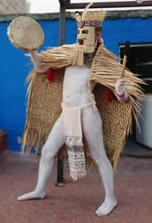 mexica man in rain cape playing drum