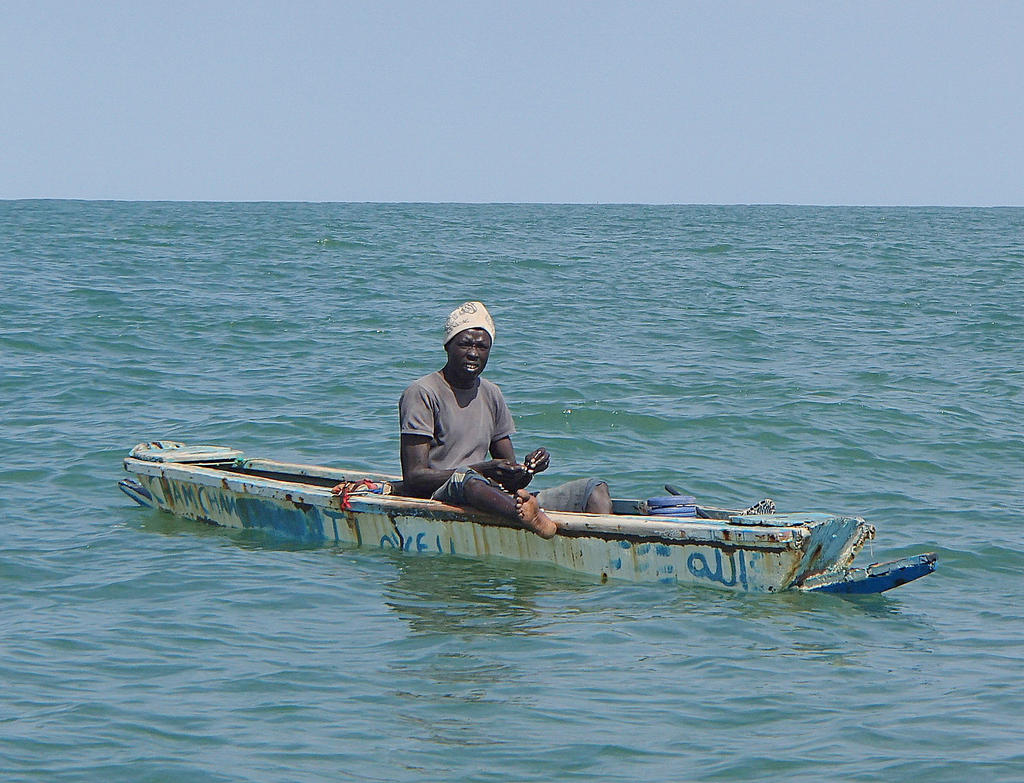 Fisherman with a line on a small boat Gambia