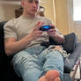 A Young Man Gaming And Relaxing hIs Feet.