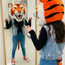 girl wearing a tiger mascot head