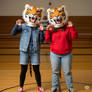 two girls wearing tiger mascot heads
