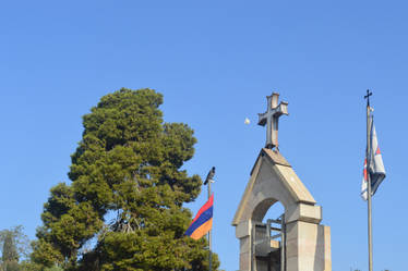 Cross, flags and white hot-air balloon.