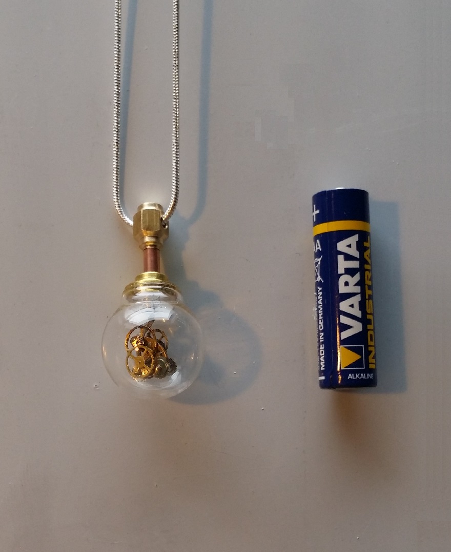 TINY steampunk pendant next to AA battery