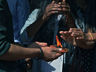 Hindu devotees taking blessings from a holy flame