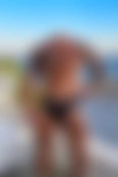 Headless muscled man near the beach