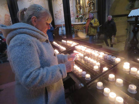 Ingeline lighting a candle in church