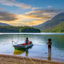 Firefly a fishing boat on a lake surrounded by mou