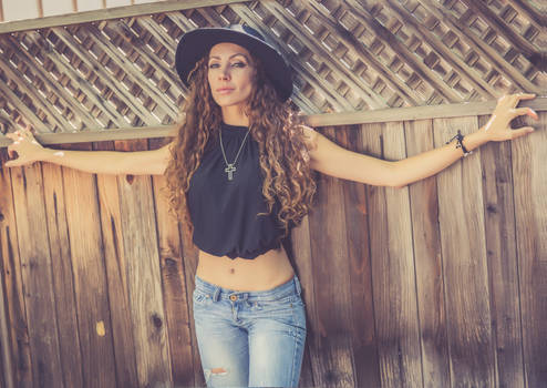 Sexy girl on the wood wall in the hat