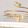 Gold tone arm band with champagne color pearls