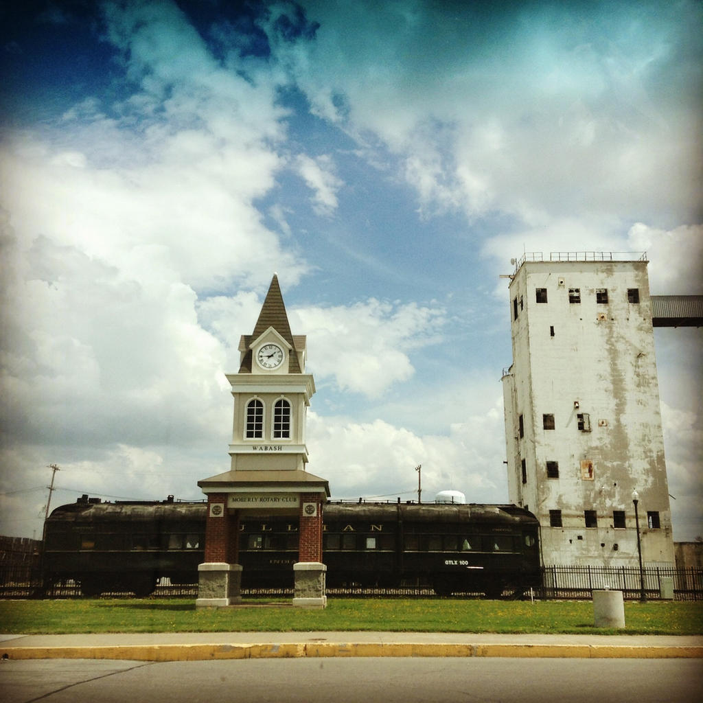 Train with a clock tower in front of it?