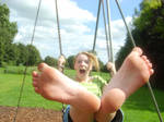 Barefoot girl in a swingset