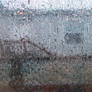 Through a window, wet with rain.