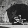 Musician Playing Guitar Under a Crumbling Arch