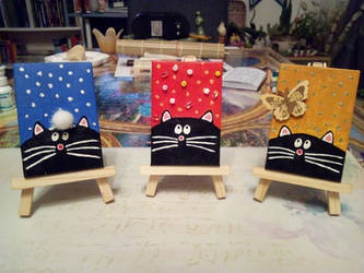 Three cats on three small easels