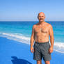 White man on beach with blue sand, Copilot version
