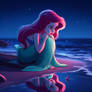 Ariel looking at her reflection on the beach