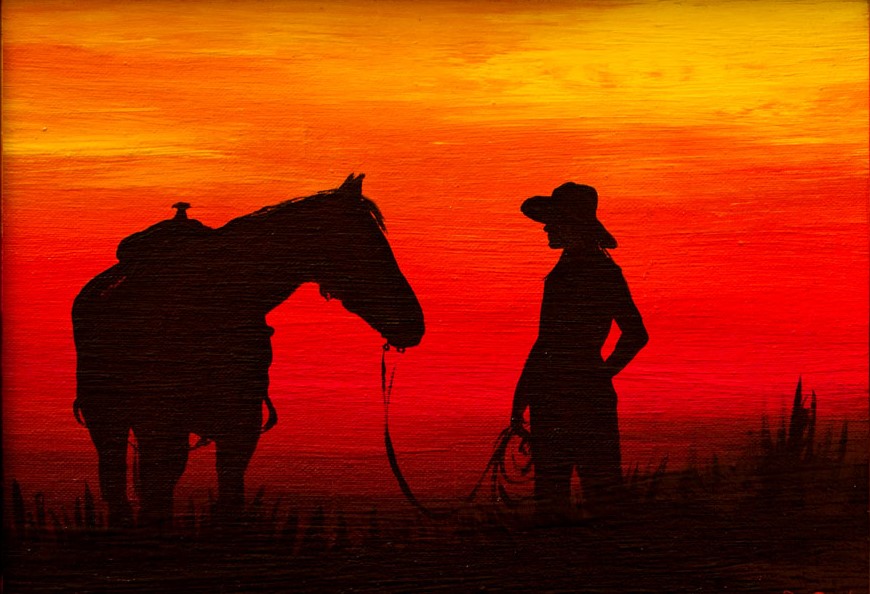 The cowgirl and her horse at sunset