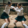 Two girls wearing white knee socks and skirts figh