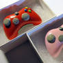 Red and Pink Xbox Controllers