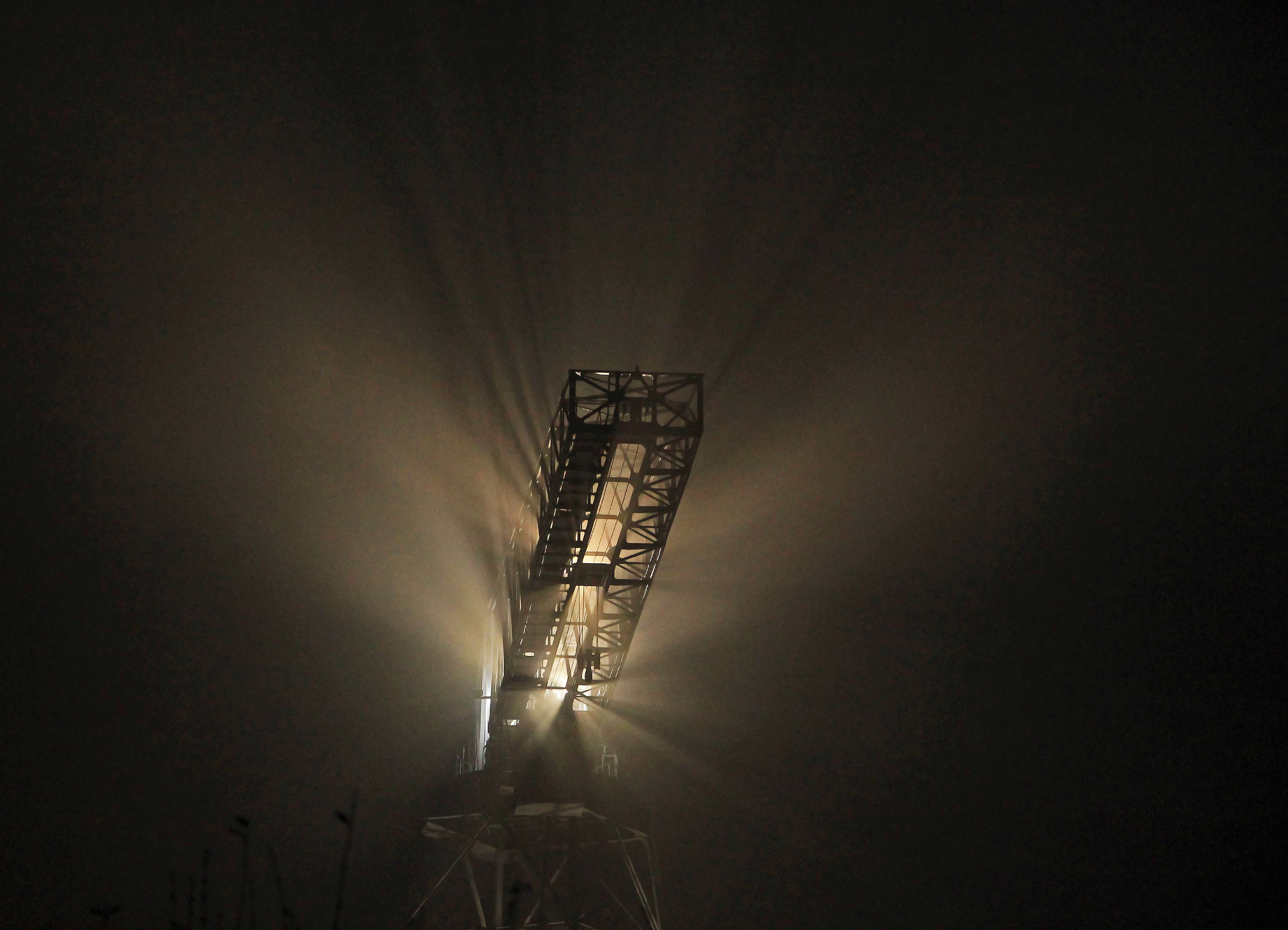 lighted crane in the mist...