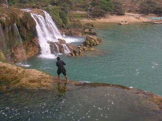 Old man fishing at waterfall