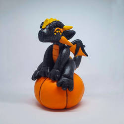 Dragon sitting on a pumpkin