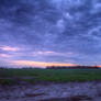 Stormy sky over field at sunset HDR