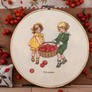 Two children carrying a basket of apple embroidery