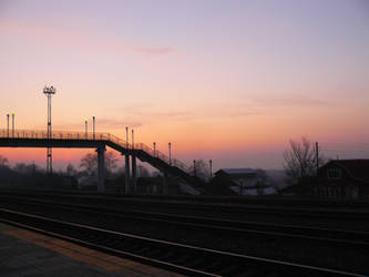 Footbridge over the railway tracks at sunset