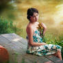 Girl in dress sitting by a lake