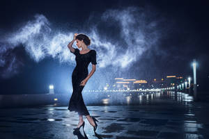 Woman in black dress posing on a city lights