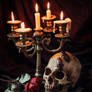 Human skull on book with antique candlestick