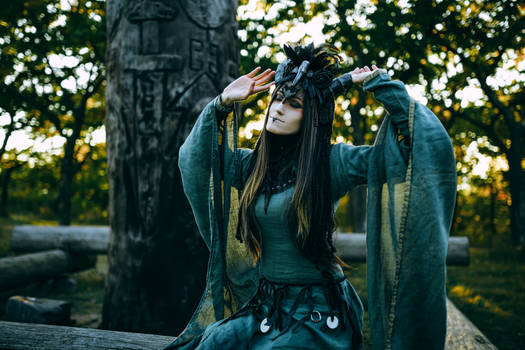 Woman-shaman with horns in  dress walk in forest