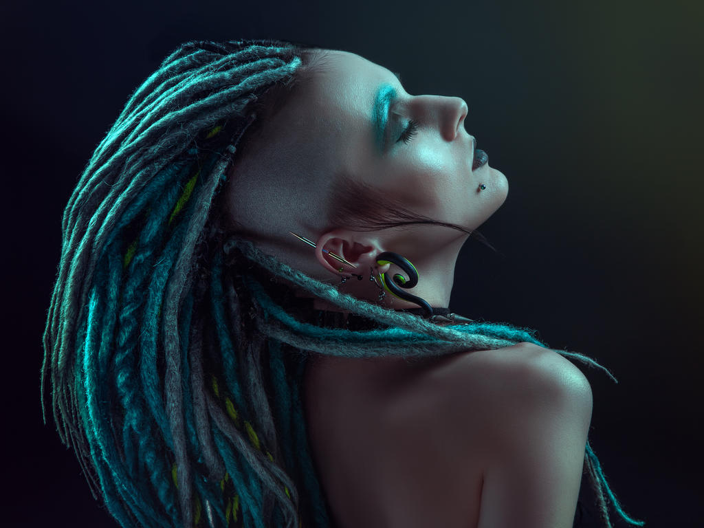 Pretty girl with dreadlocks posing in studio