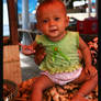 Indo Kid sitting on vegetables