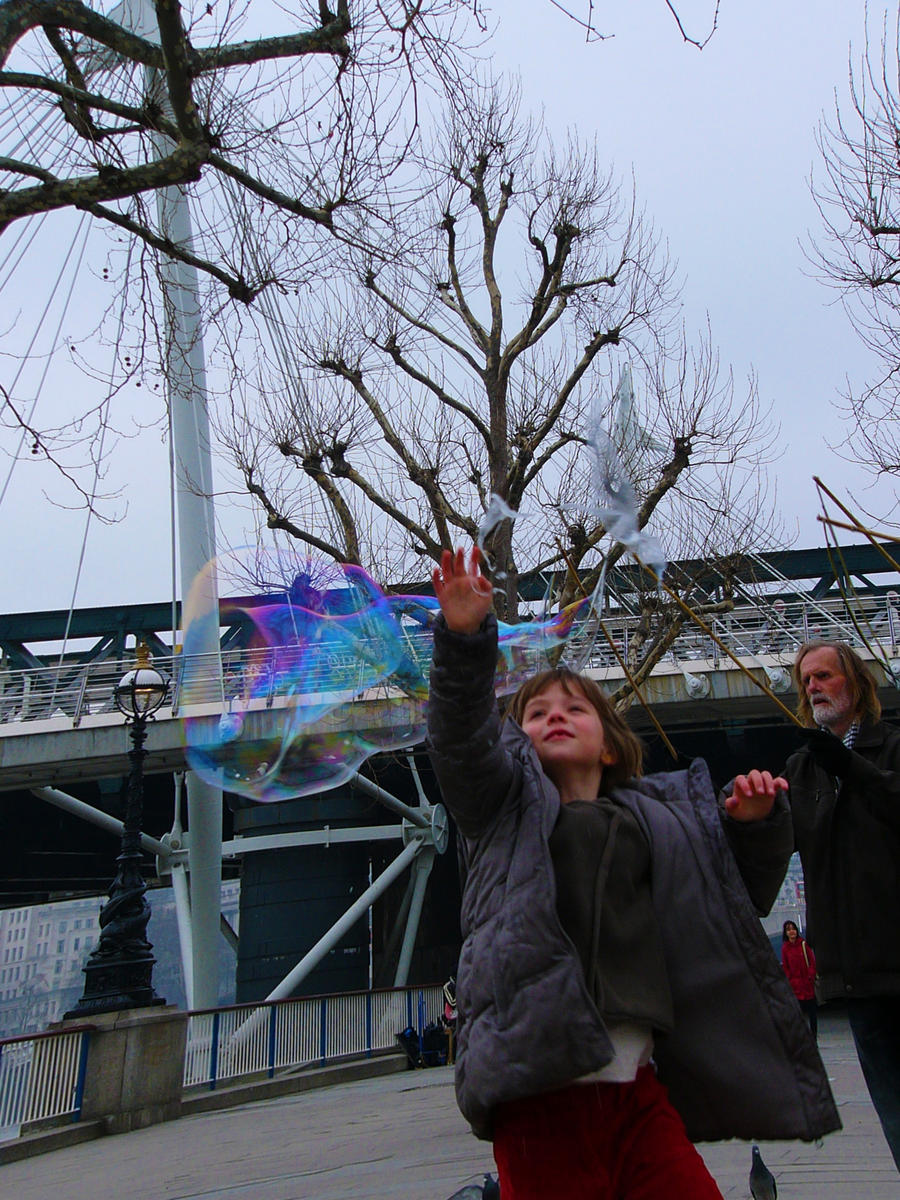 Little lady plays with soap bubbles