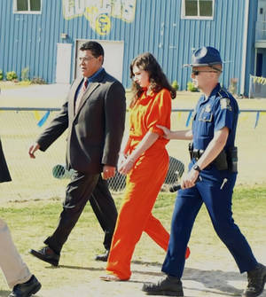 female prisoner led handcuffed 