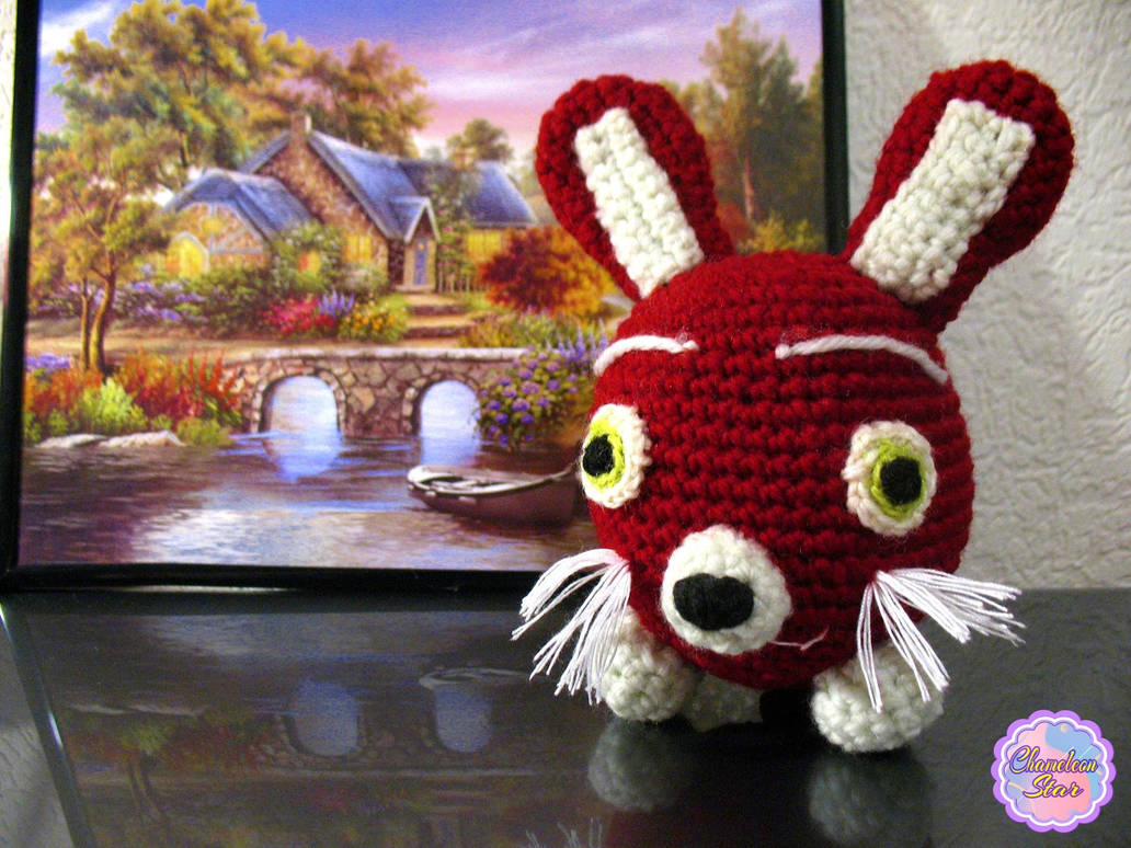 A photo of handmade crochet amigurumi burgundy red rabbit