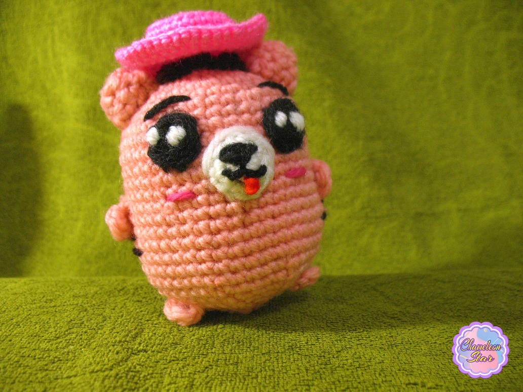 A photo of handmade crochet amigurumi pink cat named Aisling who is a part of a big Tororo Puss family